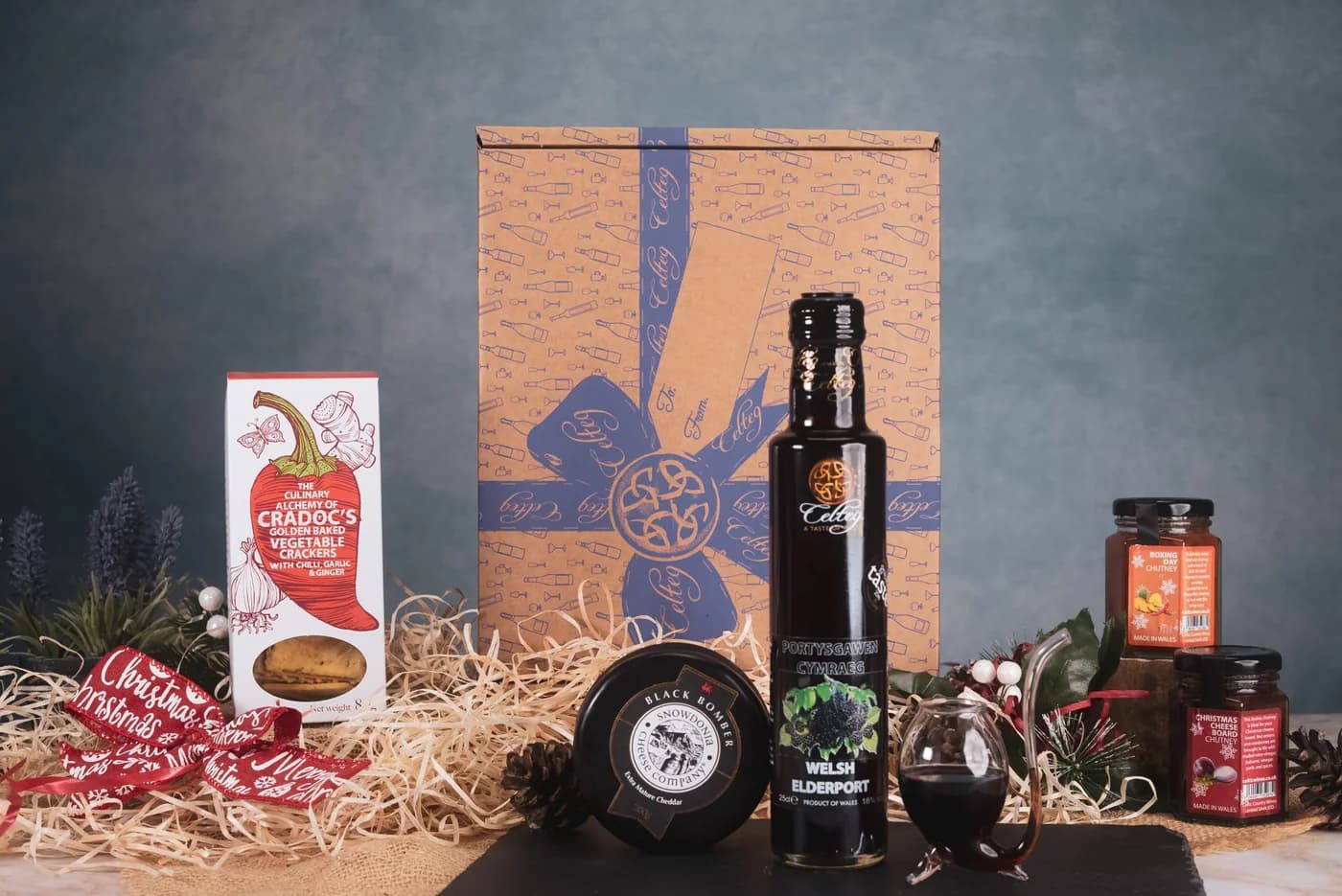 Seasonal table with mulled wine, a Christmas hamper and candlelight